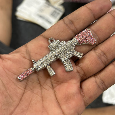 pink and iced out gun pendant